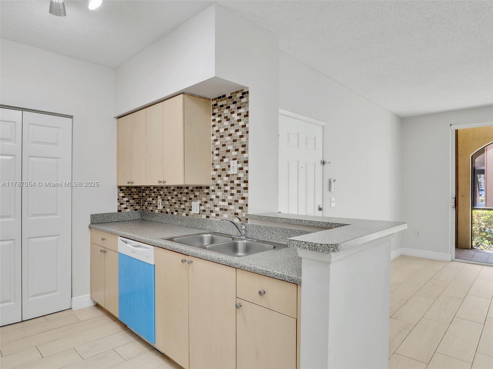 1235 Reserve Way, Unit 5107 Naples, FL 34105 - Photo 25 of 27 a kitchen with stainless steel appliances granite countertop a sink and a white cabinets