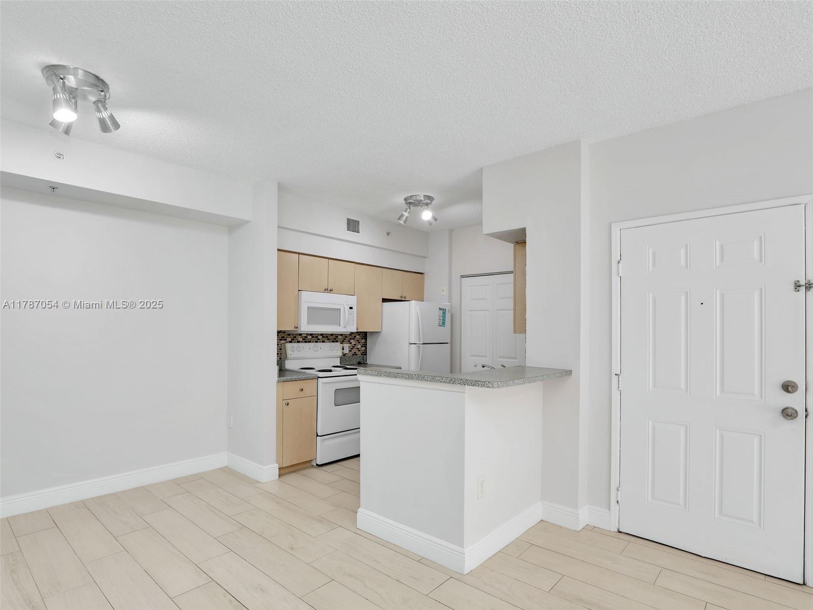 1235 Reserve Way, Unit 5107 Naples, FL 34105 - Photo 7 of 27 a kitchen with stainless steel appliances granite countertop a stove and a refrigerator