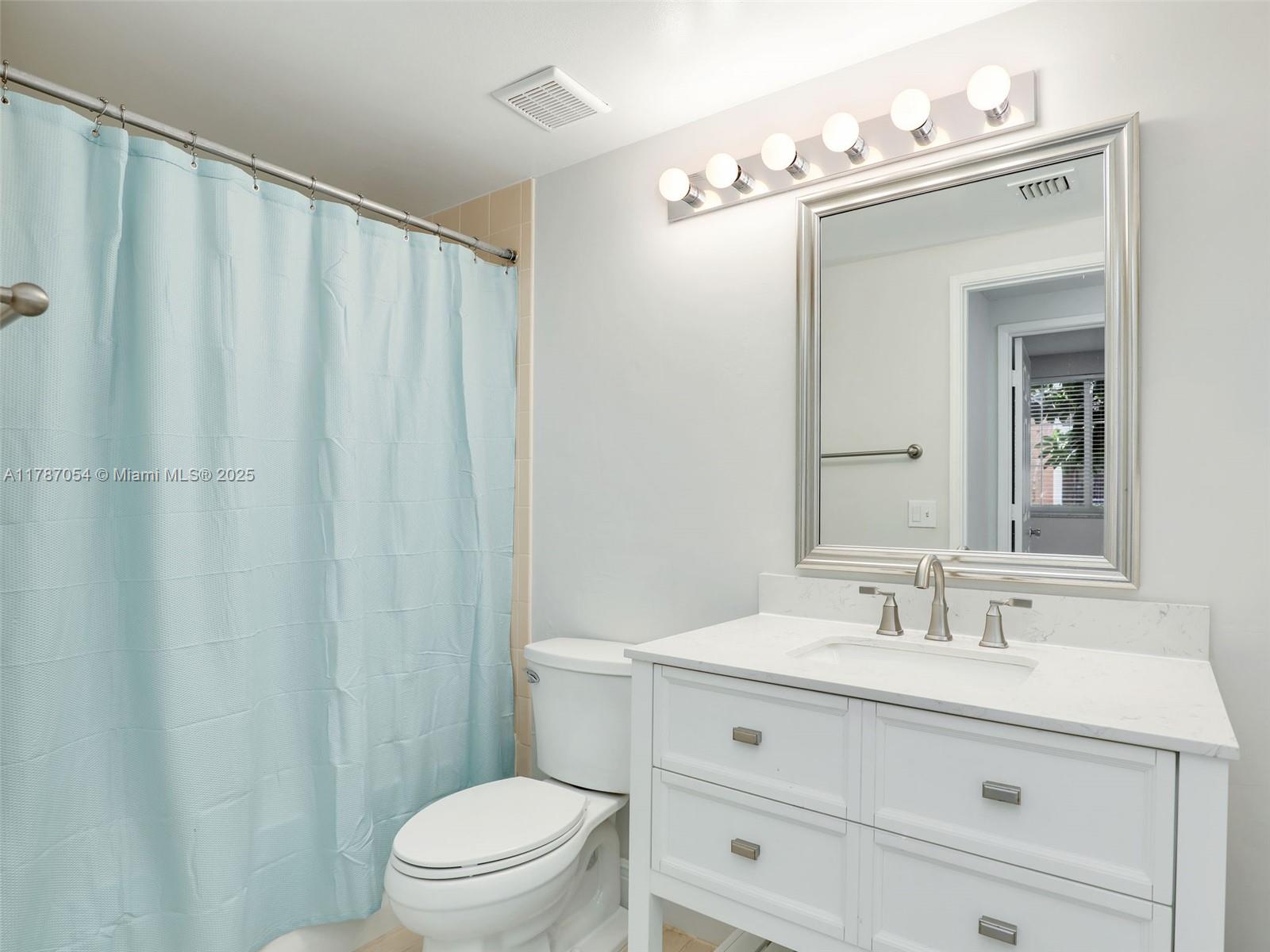 1235 Reserve Way, Unit 5107 Naples, FL 34105 - Photo 10 of 27 a bathroom with a sink mirror vanity and toilet