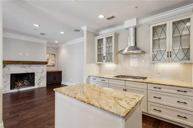 a view of an empty room with wooden floor and a fireplace