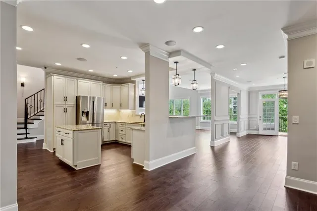 a view of an empty room with wooden floor and windows