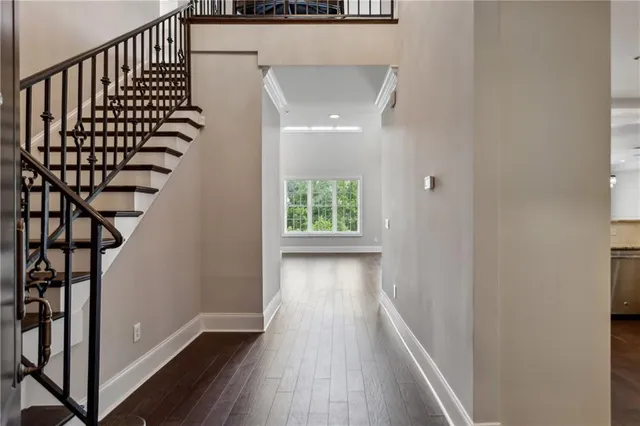 a view of a hallway with wooden floor and stairs