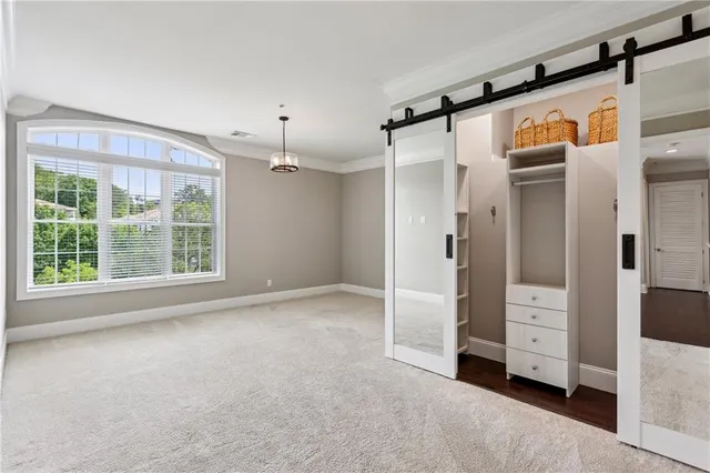 a living room with furniture large windows and wooden floor