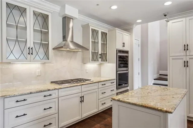 a kitchen with granite countertop a stove and a wooden floor