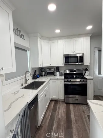 a kitchen with stainless steel appliances a refrigerator sink and cabinets