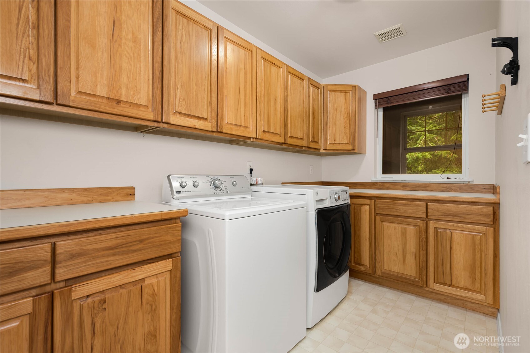 14638 Gibralter Road Anacortes, WA 98221 - Photo 15 of 25 a utility room with stainless steel appliances granite countertop a sink and dishwasher with wooden cabinets