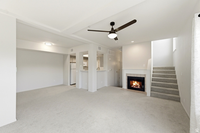 900 Bitner Road, Unit P20 Park City, UT 84098 - Photo 4 of 42 Carpeted living area featuring a fireplace with a white mantel, ceiling fan, and a light-toned kitchen with white appliances