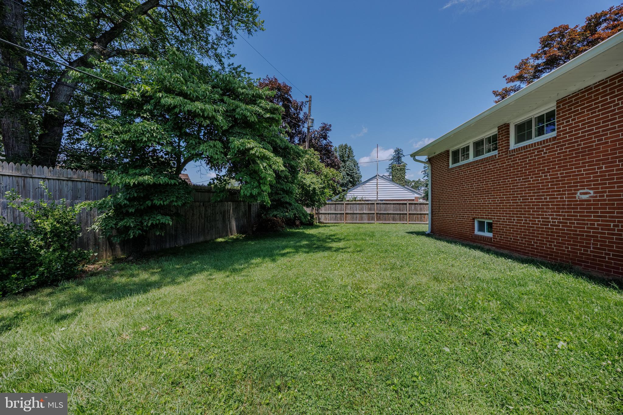 1305 Heather Hill Road Baltimore, MD 21239 - Photo 45 of 50 Backyard w/ grassy area, trees, and a wooden fence