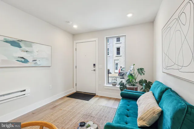 a view of a hallway with wooden floor and a bathroom