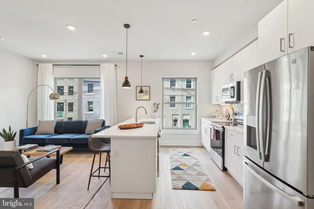 a kitchen with stainless steel appliances kitchen island granite countertop a refrigerator and a stove top oven