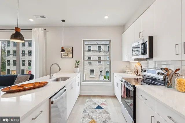 a kitchen that has a lot of cabinets in it and wooden floors
