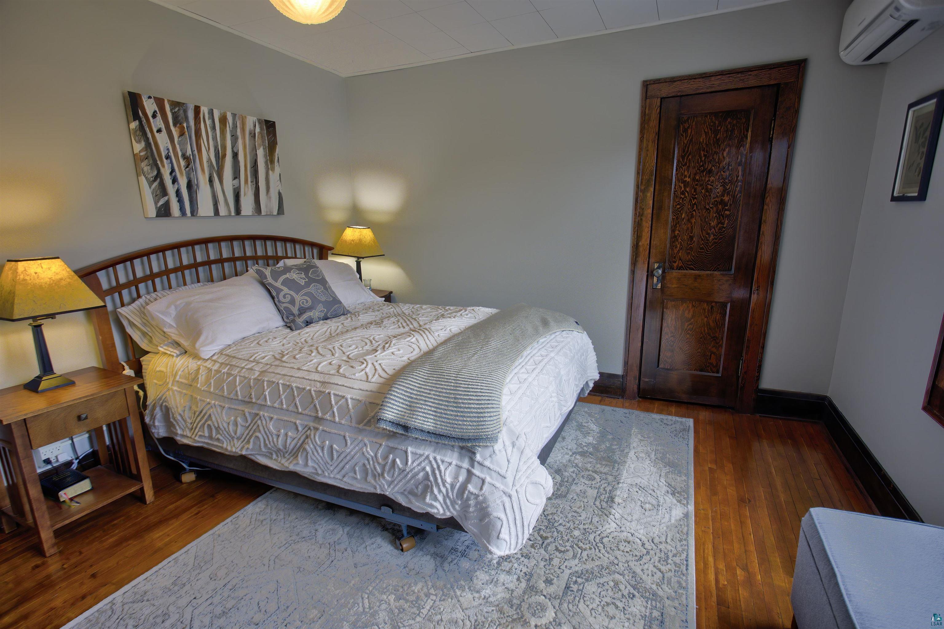 24 East Conan Street Ely, MN 55731 - Photo 13 of 27 Hardwood flooring, dark wood trim, and a paneled wood door