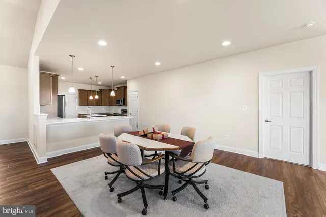a dining room with furniture and kitchen view