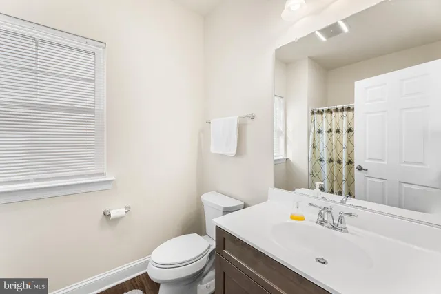 a bathroom with a sink toilet and a mirror