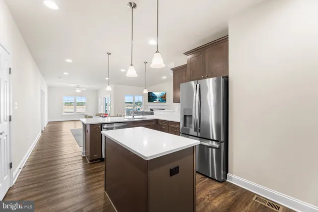 a kitchen with kitchen island a sink appliances and wooden floor
