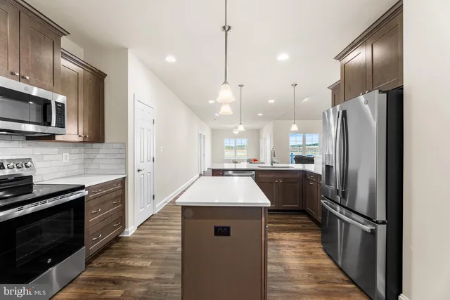 a kitchen with kitchen island a counter top space stainless steel appliances and cabinets