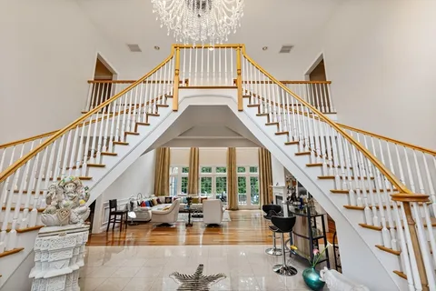 a view of staircase with lots of frames on and white walls
