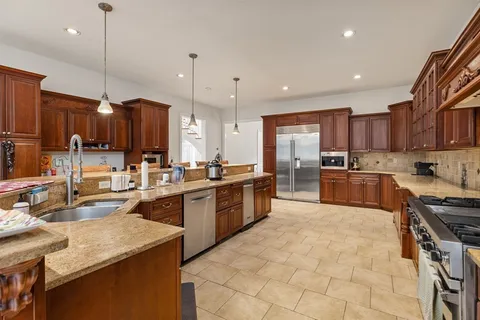 a kitchen with kitchen island granite countertop wooden cabinets and a center island