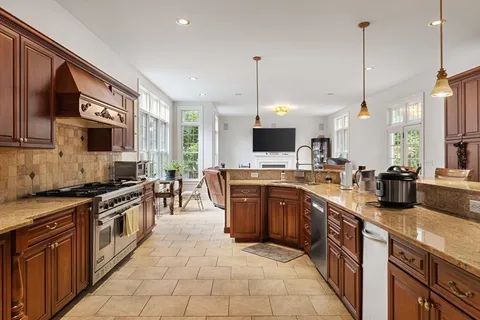 a kitchen with stainless steel appliances granite countertop a sink a stove and a wooden floor