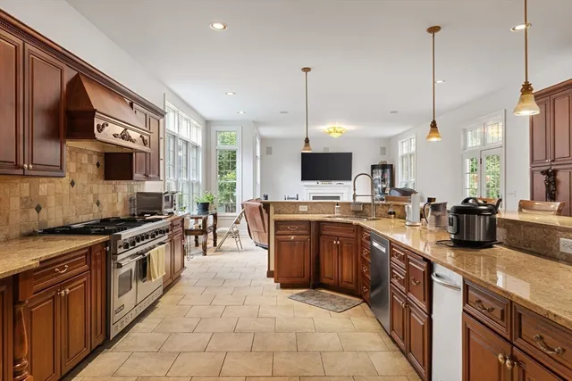 a kitchen with stainless steel appliances granite countertop a sink a stove and a wooden floor