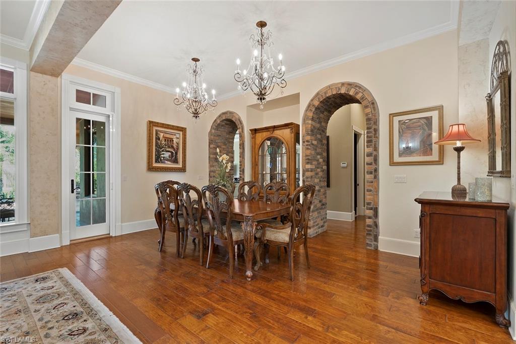 611 18th Avenue South Naples, FL 34102 - Photo 36 of 44 Dining area with crown molding, dark wood-type flooring, arched walkways, and a chandelier