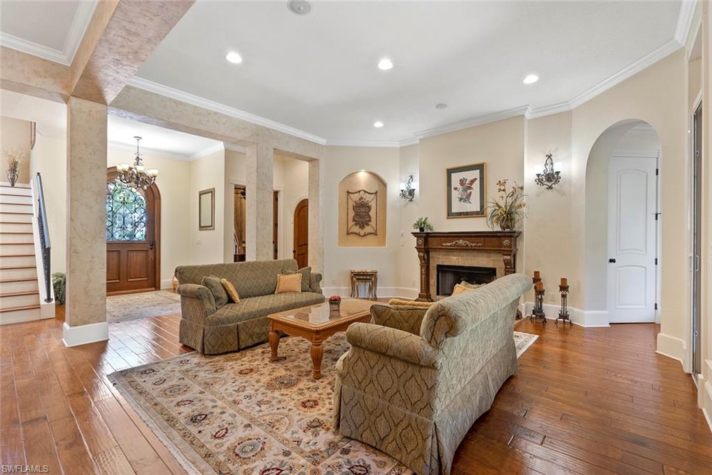 611 18th Avenue South Naples, FL 34102 - Photo 40 of 44 Living area featuring ornamental molding, arched walkways, hardwood / wood-style floors, a fireplace, and stairs