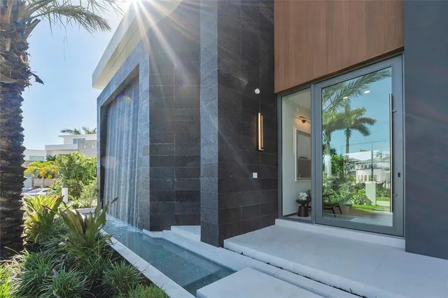 a dining room with kitchen island furniture large windows and a chandelier