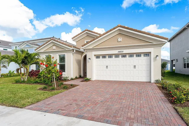 a front view of a house with a yard and garage