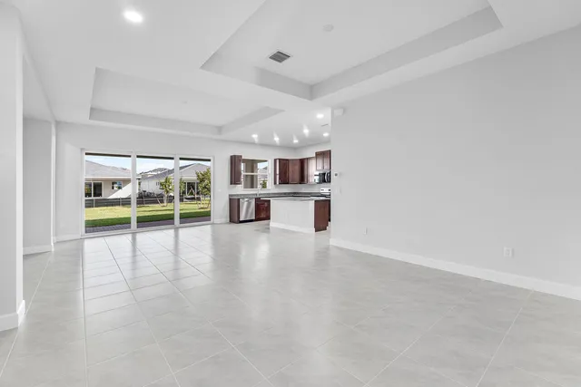 a view of kitchen with refrigerator stove and cabinets