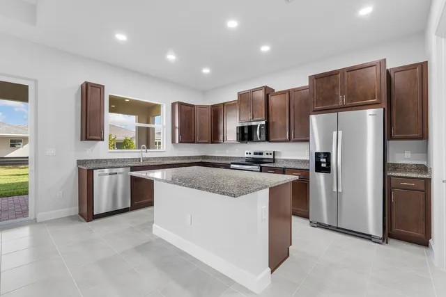 a kitchen with stainless steel appliances granite countertop a sink stove and cabinets