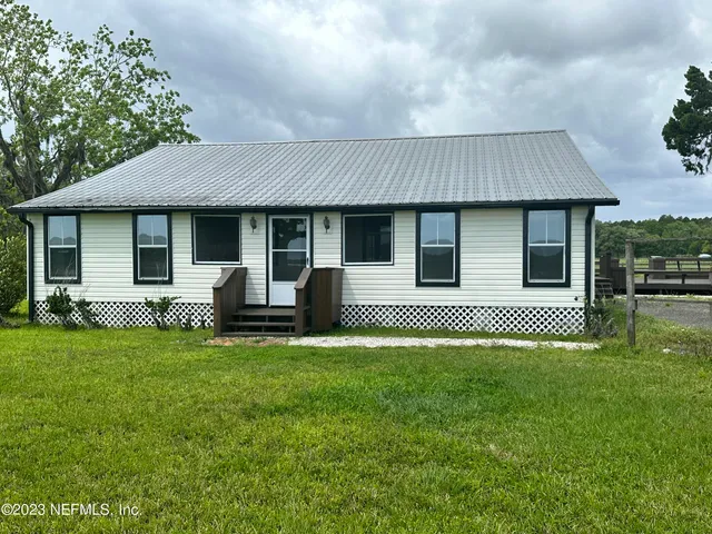 a house that has a big yard with wooden fence