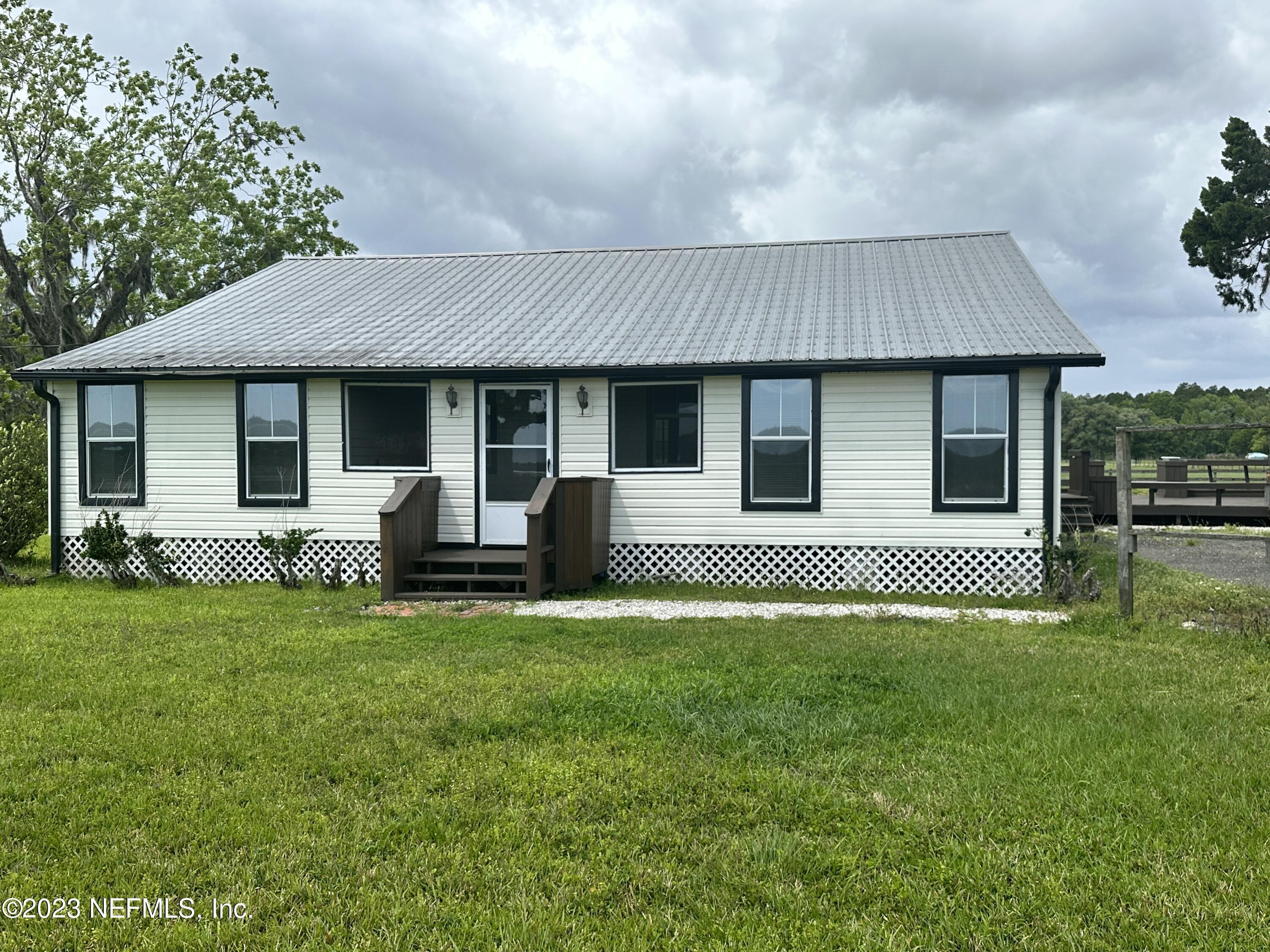 a house that has a big yard with wooden fence