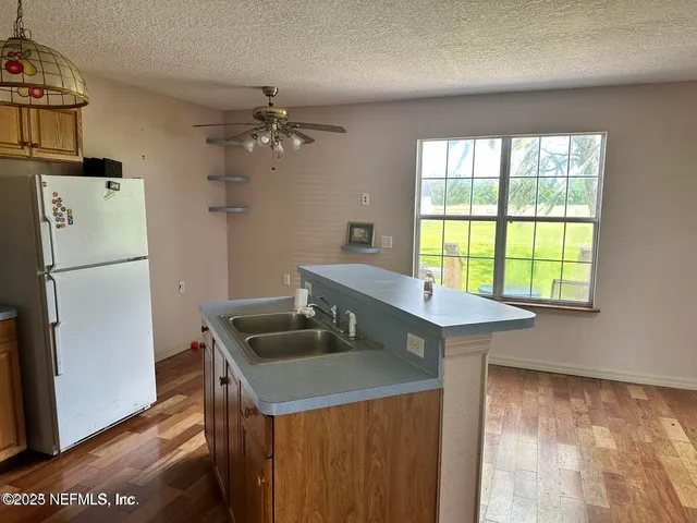 a kitchen with a refrigerator a sink dishwasher with a dining table and chairs