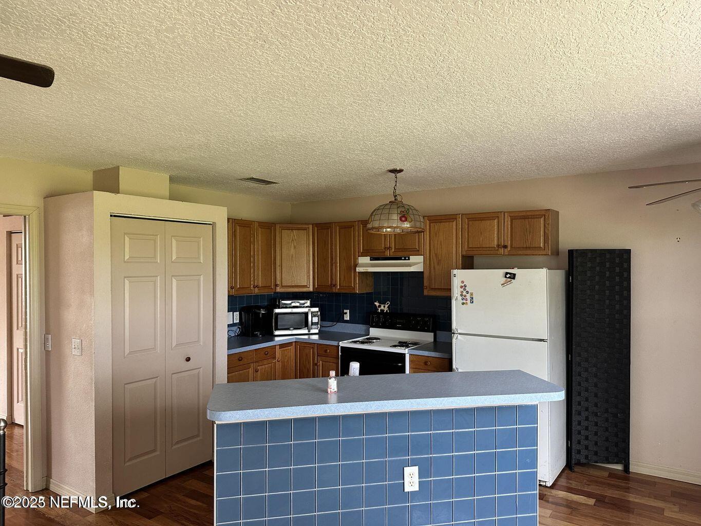 9465 Cowpen Branch Road, Unit A Hastings, FL 32145 - Photo 17 of 21 a kitchen with refrigerator and cabinets