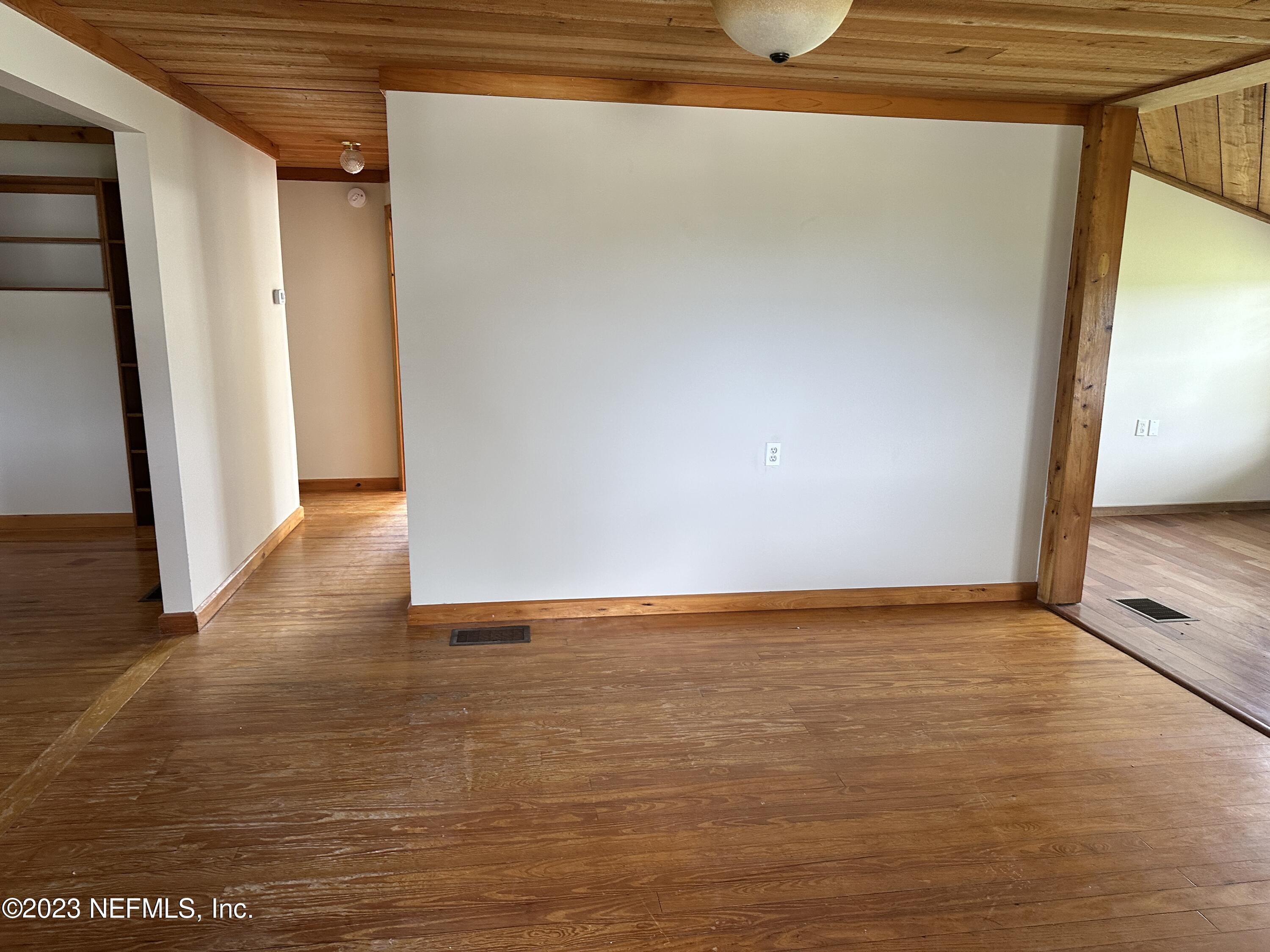 9465 Cowpen Branch Road, Unit A Hastings, FL 32145 - Photo 4 of 21 a view of an empty room with wooden floor and a window