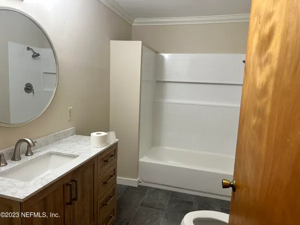 a bathroom with a granite countertop sink mirror toilet and bathtub
