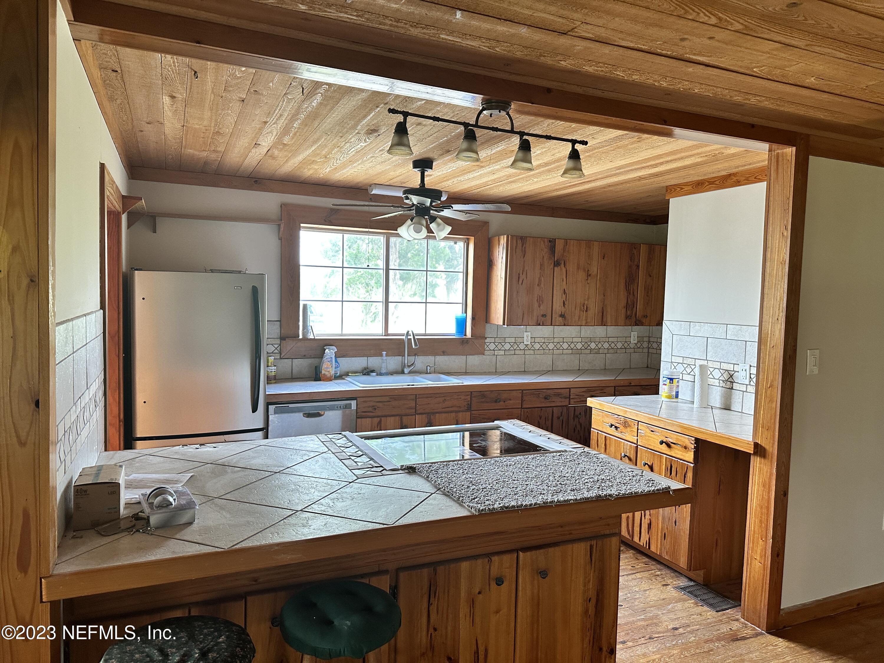9465 Cowpen Branch Road, Unit A Hastings, FL 32145 - Photo 10 of 21 a kitchen with a sink and a refrigerator
