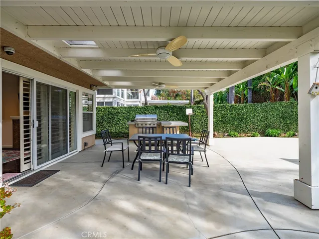 a view of a patio with a table and chairs under an umbrella