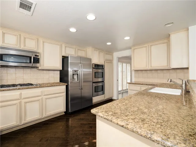 a kitchen with stainless steel appliances granite countertop a sink stove and refrigerator