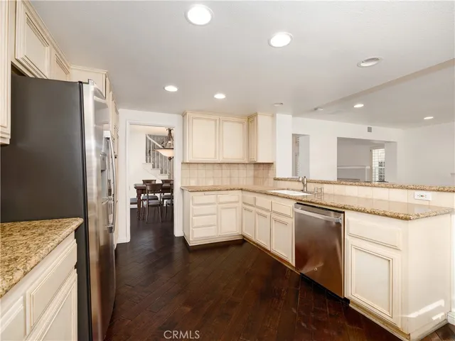a kitchen with granite countertop white cabinets and refrigerator