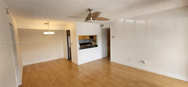 a view of a kitchen with a sink and refrigerator
