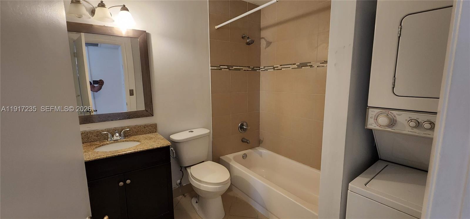 10029 Winding Lake Road, Unit 201 Sunrise, FL 33351 - Photo 12 of 22 a bathroom with a granite countertop toilet sink and mirror