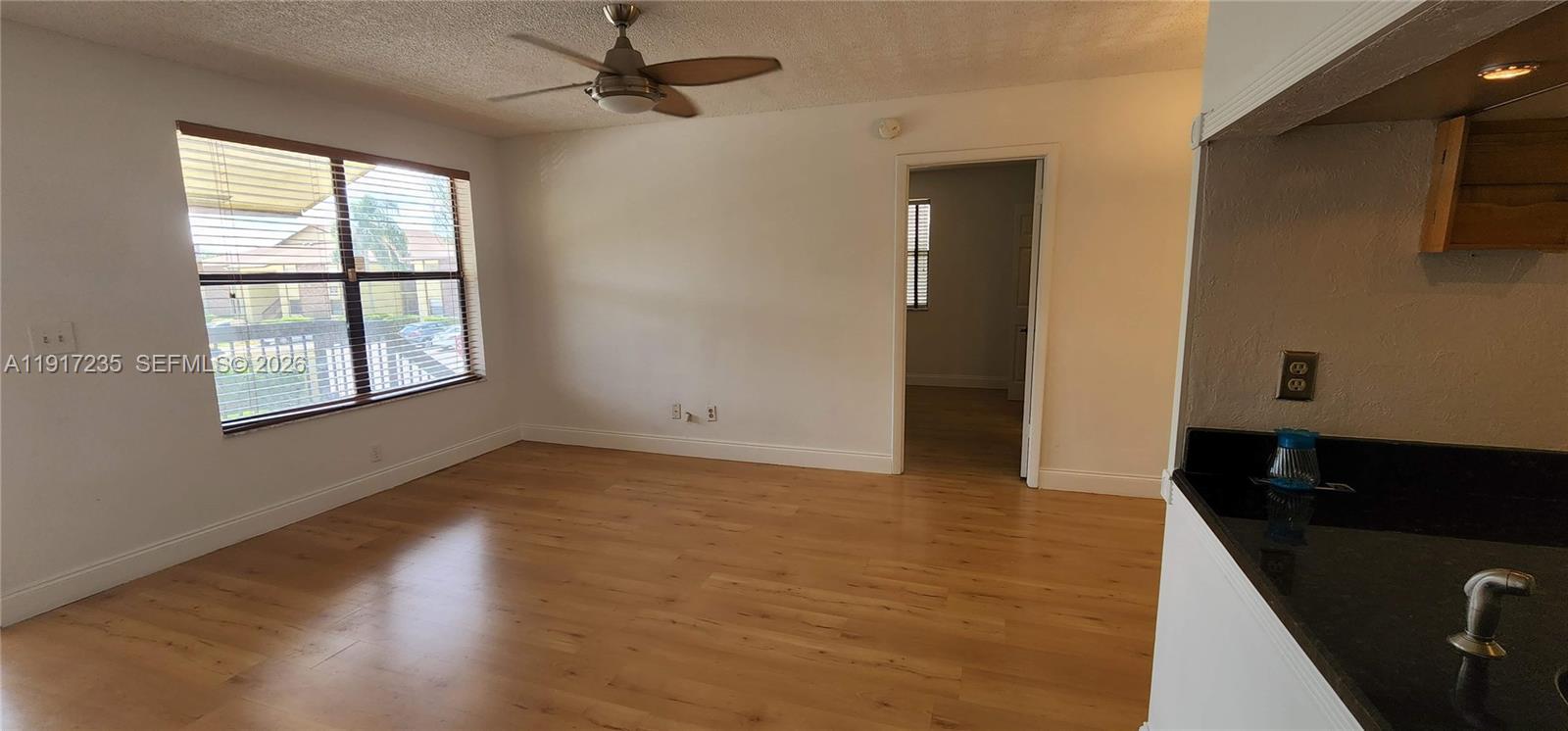 10029 Winding Lake Road, Unit 201 Sunrise, FL 33351 - Photo 14 of 22 an empty room with wooden floor and windows
