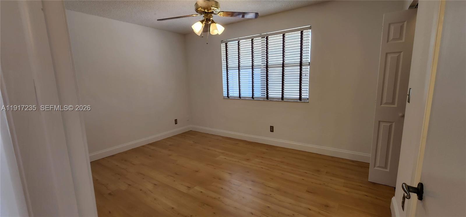 10029 Winding Lake Road, Unit 201 Sunrise, FL 33351 - Photo 15 of 22 wooden floor in an empty room with a window