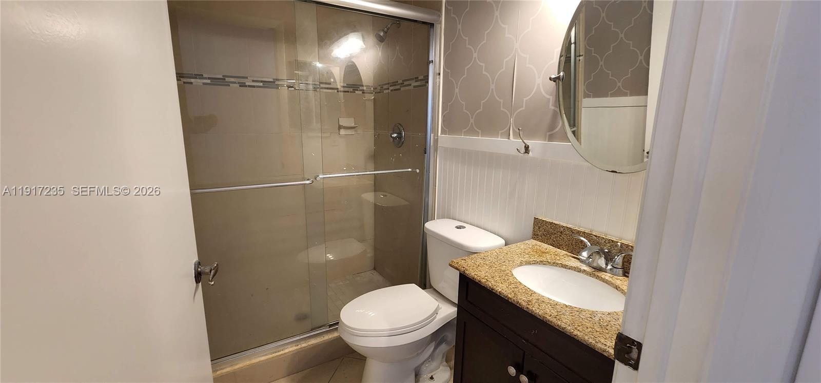 10029 Winding Lake Road, Unit 201 Sunrise, FL 33351 - Photo 18 of 22 a bathroom with a granite countertop toilet and a sink