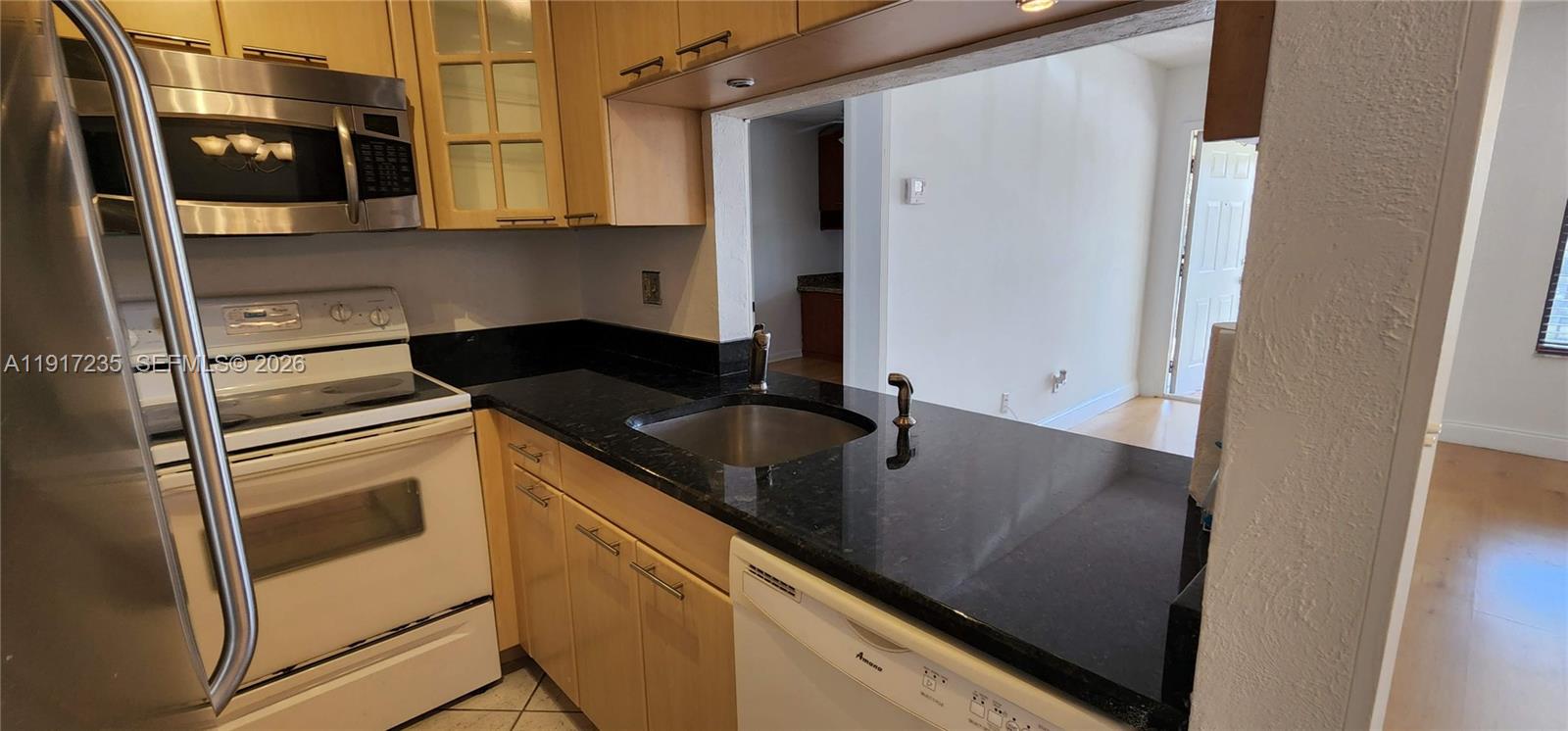 10029 Winding Lake Road, Unit 201 Sunrise, FL 33351 - Photo 8 of 22 a kitchen with a sink and a refrigerator