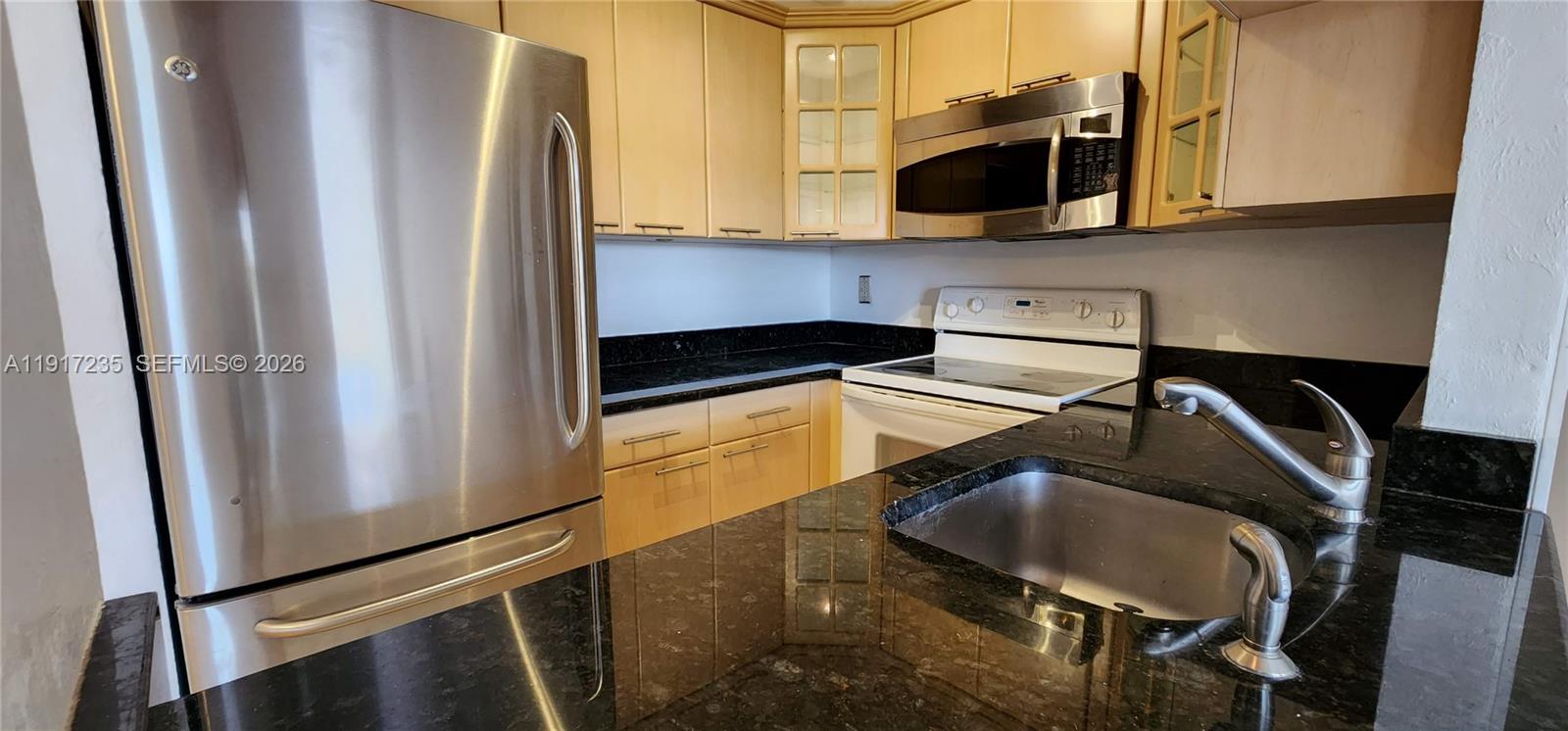 10029 Winding Lake Road, Unit 201 Sunrise, FL 33351 - Photo 9 of 22 a kitchen with stainless steel appliances granite countertop a refrigerator and a stove top oven