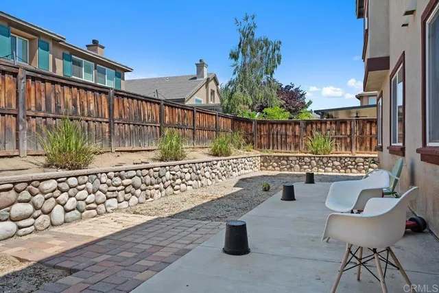 a side view of a chairs and table in the patio