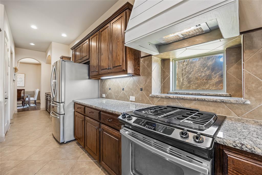 1206 Wedgewood Drive Forney, TX 75126 - Photo 19 of 40 a kitchen with a stove and a refrigerator