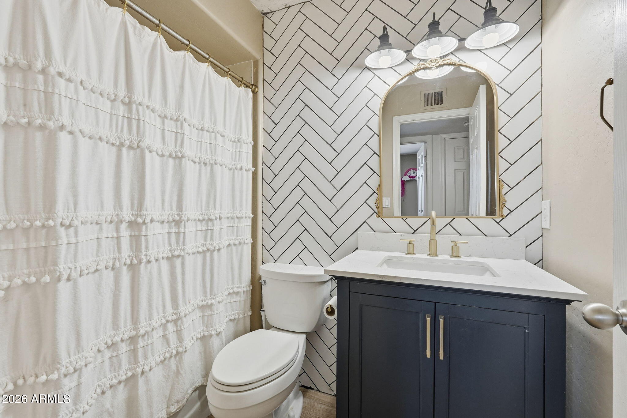 2858 East Redfield Road Gilbert, AZ 85234 - Photo 39 of 60 a bathroom with a sink a toilet and shower curtain